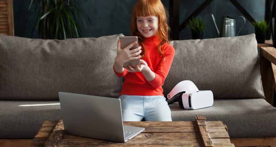 a child with a tablet in his hands is sitting on the sofa